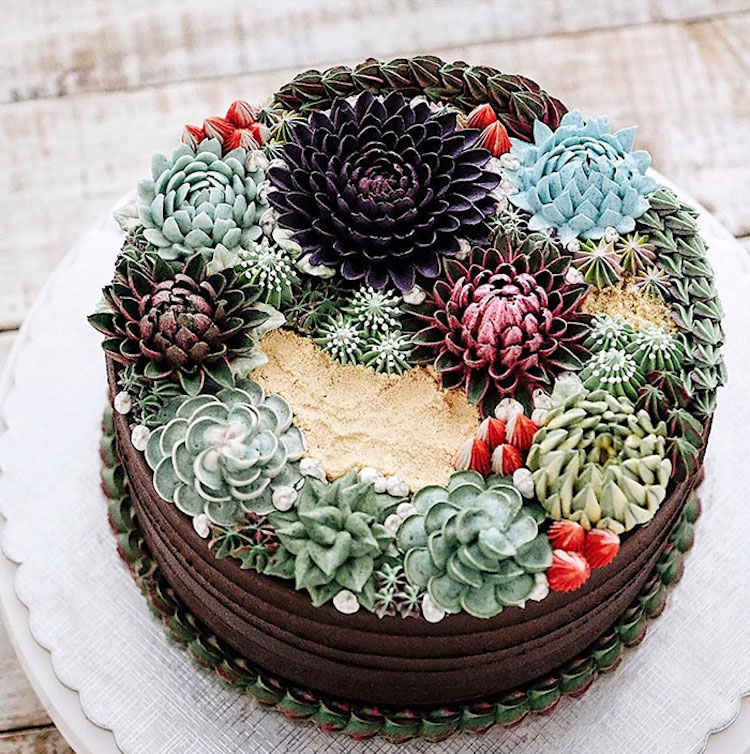 Buttercream piped succulents in deep tones of green and purple on a round chocolate cake by Ivenoven Succulent Cakes